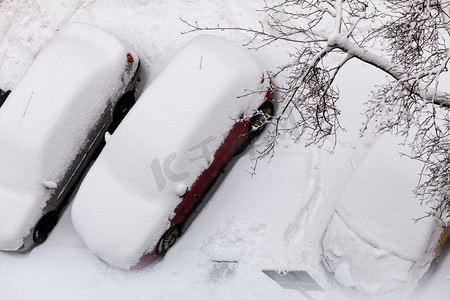 运输，冬季和季节特定。停在雪覆盖后暴风雪顶视图的汽车。冬季暴风雪后停车