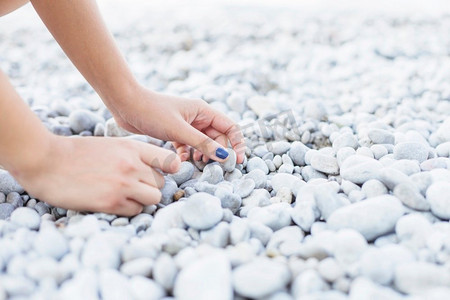 女子的手捡卵石海滩