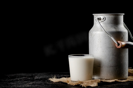 质朴的牛奶罐头和桌上的玻璃杯.瓶子杯子