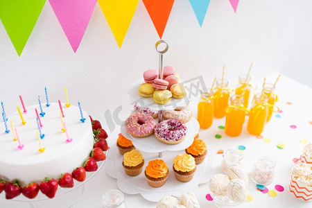 派对和节日概念—生日蛋糕，蜡烛和草莓，饮料和食物上桌。生日派对上的食物和饮料