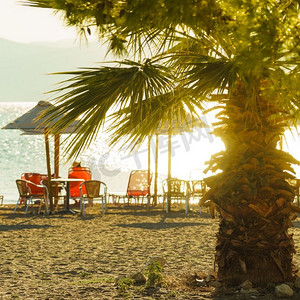 太阳伞在沙滩上没有人靠近海水的躺椅上给阴影。沙滩上的太阳伞和躺椅