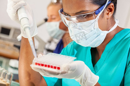 印度女性摄影照片_在医学研究实验室或实验室使用吸管和样本托盘进行血液测试的印度亚裔女科学家或医生