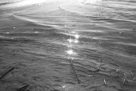 从水中的沙子上的痕迹和污渍黑色和白色 