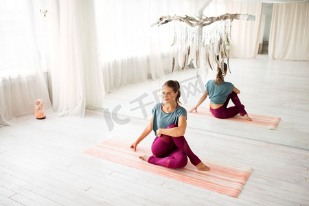 健身，运动和健康的生活方式概念—妇女做瑜伽练习在工作室。女人做瑜伽练习在工作室