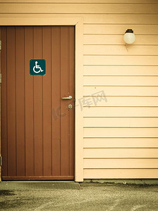 户外公共厕所、卫生间洗手间门上的蓝色残疾人轮椅标志。公共厕所门上的蓝色残疾人轮椅标志