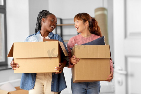 移动，人和房地产概念—快乐的微笑妇女与盒子在新家。带着箱子搬到新家的妇女
