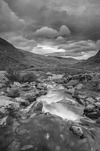 秋天斯诺多尼亚的Llyn Ogwen和Llyn Idwal附近河流顺流而下的黑白风景图像