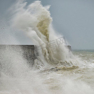 在英国海岸纽哈文的狂风风暴中，令人惊叹的海浪冲击着港口的墙壁。