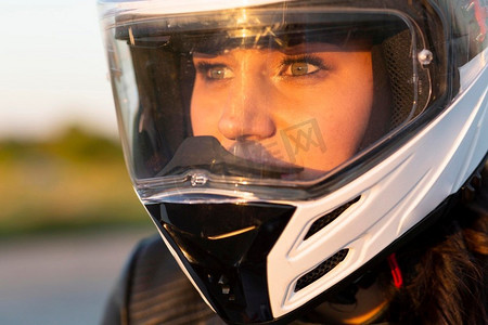 一名妇女戴着头盔骑摩托车