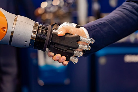 一位商人的手与机器人握手。人类与人工智能互动的概念。