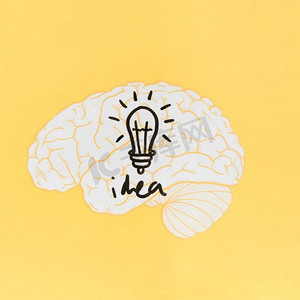 想象力创造力摄影照片_有灯泡的想法词在大脑黄色背景里面