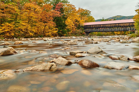 汉普郡摄影照片_秋天，美国新罕布什尔州白山国家森林公园的斯威夫特河和旧覆盖的奥尔巴尼大桥。秋天在新英格兰。 