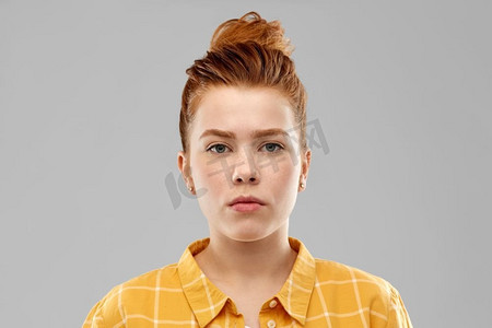 人们概念—红色头发的少女的肖像在灰色背景的格子衬衫。红头发少女肖像