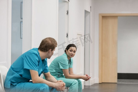 男女谈话摄影照片_男女护士在医院坐在走廊上谈话