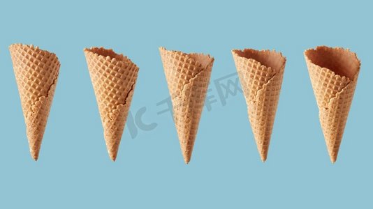 冰淇淋袋摄影照片_一个不同的角度的华夫饼甜筒冰淇淋的模式在蓝色背景。威化糖罐的前景
