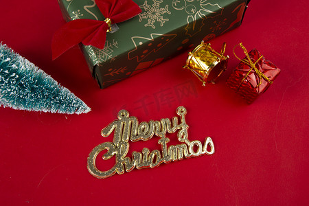 红色立牌摄影照片_圣诞节平安夜红底图纯色蝴蝶结金色礼物字母牌