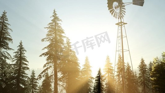 黄色风车摄影照片_典型的老风车涡轮机在森林在日落