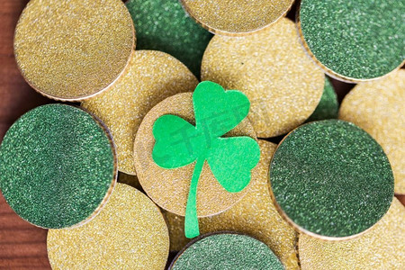 财富，运气和圣帕特里克节概念—关闭金币和绿色三叶草叶。关闭金币和绿色三叶草叶