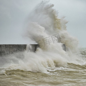 在英国海岸的纽黑文的暴风雨中，惊人的海浪撞击在港口墙壁上