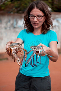 手里拿鱼摄影照片_斯里兰卡的女孩游客手里拿着巨大的螃蟹