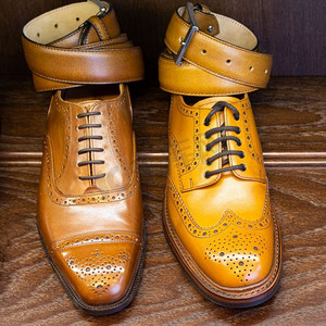 棕色和棕褐色的全粒面皮鞋在木制显示带在男鞋精品店。男士鞋业精品店