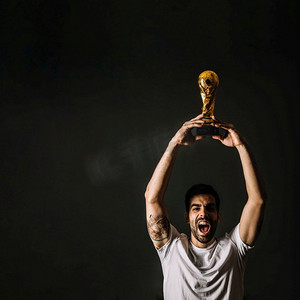 卡塔尔奖杯摄影照片_男子手持国际足联奖杯庆祝胜利