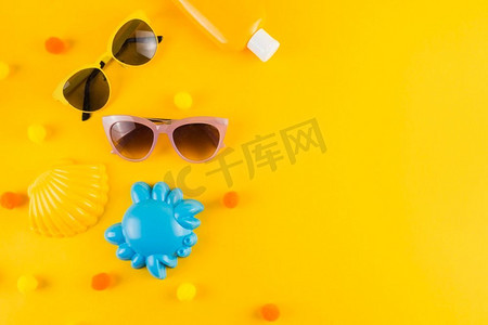 俯视太阳镜防晒乳液瓶扇贝蟹玩具黄色背景