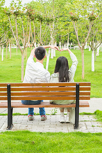 情侣用手臂比心爱情公园长椅