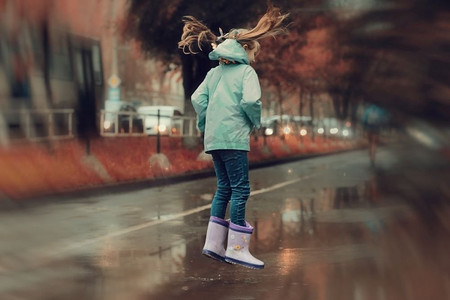 秋雨摄影照片_女孩在秋雨中跳进水坑