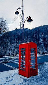 经典的红色英国电话盒在雪的街道在Sinaia，喀尔巴阡山，罗马尼亚