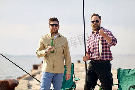钓竿折断摄影照片_休闲和人的概念—快乐的朋友与钓竿，鱼和啤酒码头在海上。快乐的朋友与钓竿和啤酒码头