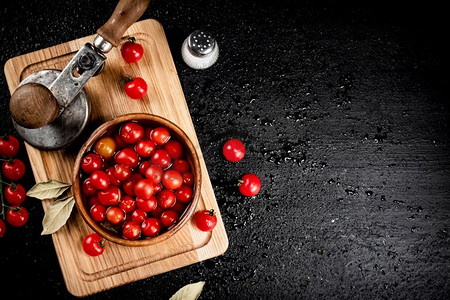 在切菜板上腌制成熟的西红柿。在黑色背景上。高质量的照片。在切菜板上腌制成熟的西红柿。