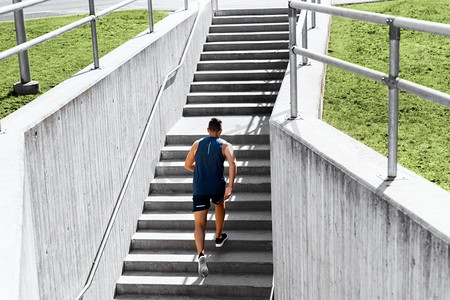 健身，运动和健康的生活方式概念—年轻人上楼跑步。年轻人跑上楼