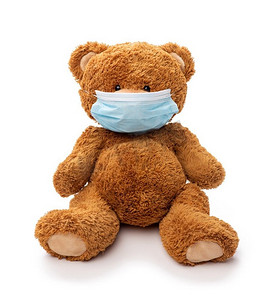 医药，保健和流行病概念—泰迪熊玩具在保护医疗面具在白色背景。医用防护口罩玩具玩具
