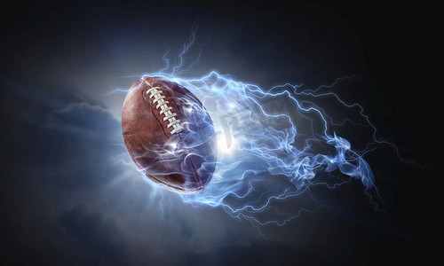 黑暗背景下闪电中的橄榄球。混合媒体。美式橄榄球比赛