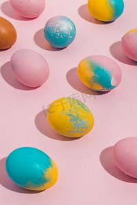 彩色复活节彩蛋散落粉红色桌子
