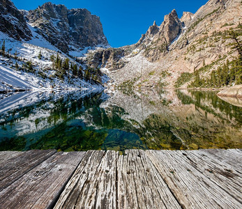 翡翠湖和反射与岩石和山脉在雪周围在秋天。美国科罗拉多州落基山国家公园。 