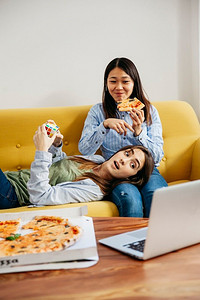内容框摄影照片_内容女孩看笔记本电脑吃披萨