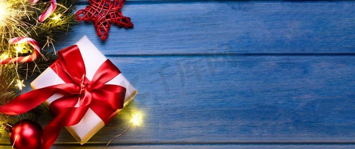 圣诞节或新年礼物与火花和节日冷杉树在蓝色桌子在晚上。圣诞或新年礼物