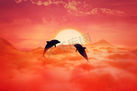 两个嬉戏的海豚的剪影跳跃在云彩反对日落背景。超现实的野生动物风景场景屏幕保护程序