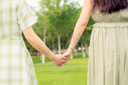 闺蜜牵手散步特写友情公园草地夏天