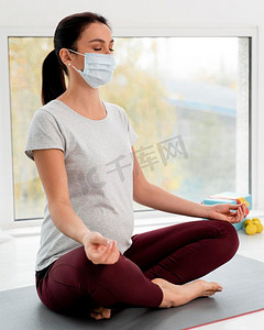 孕妇戴着医用口罩做瑜伽