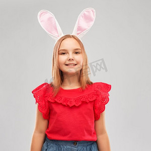 祝大家兔年快乐摄影照片_复活节，假日和童年概念—愉快的女孩穿着兔子耳朵头带在灰色背景快乐的女孩穿着复活节兔子耳朵头带