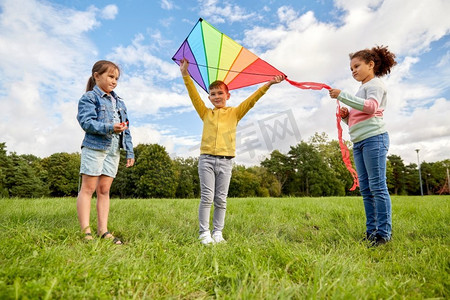 童年、休闲和人的概念-一群快乐的孩子在公园里放风筝。快乐的孩子们在公园里放风筝