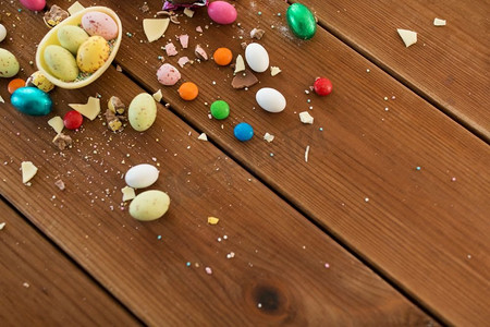 复活节，糖果和糖果概念—巧克力蛋和糖果滴在木桌。巧克力蛋和糖果滴在木桌上