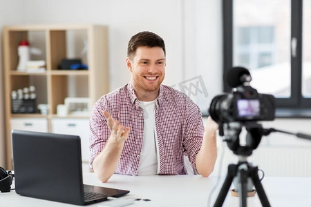 博客，videoblog和人的概念—男性博客与相机录制视频博客在家庭办公室。男性博客与相机videobblogging在家里