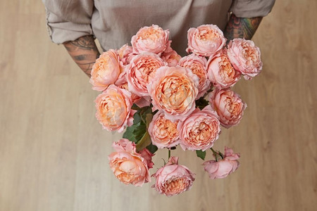 情人玫瑰摄影照片_有一束粉红色媒体玫瑰的妇女，顶视图。母亲节，情人节。’’女人与一束玫瑰媒体