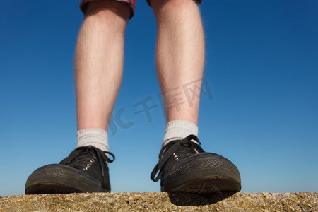 男性脚穿着黑色运动鞋户外广角看法。男性脚穿着运动鞋户外