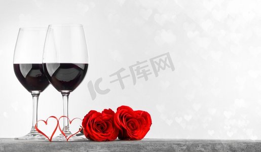 情人节赠送两杯红酒、玫瑰和心形彩带。红酒玫瑰和红心