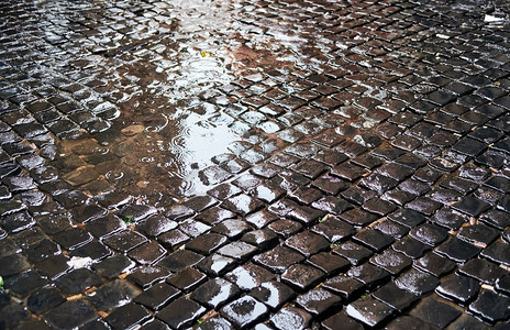 罗马人摄影照片_鹅卵石砖铺湿街道在罗马，意大利